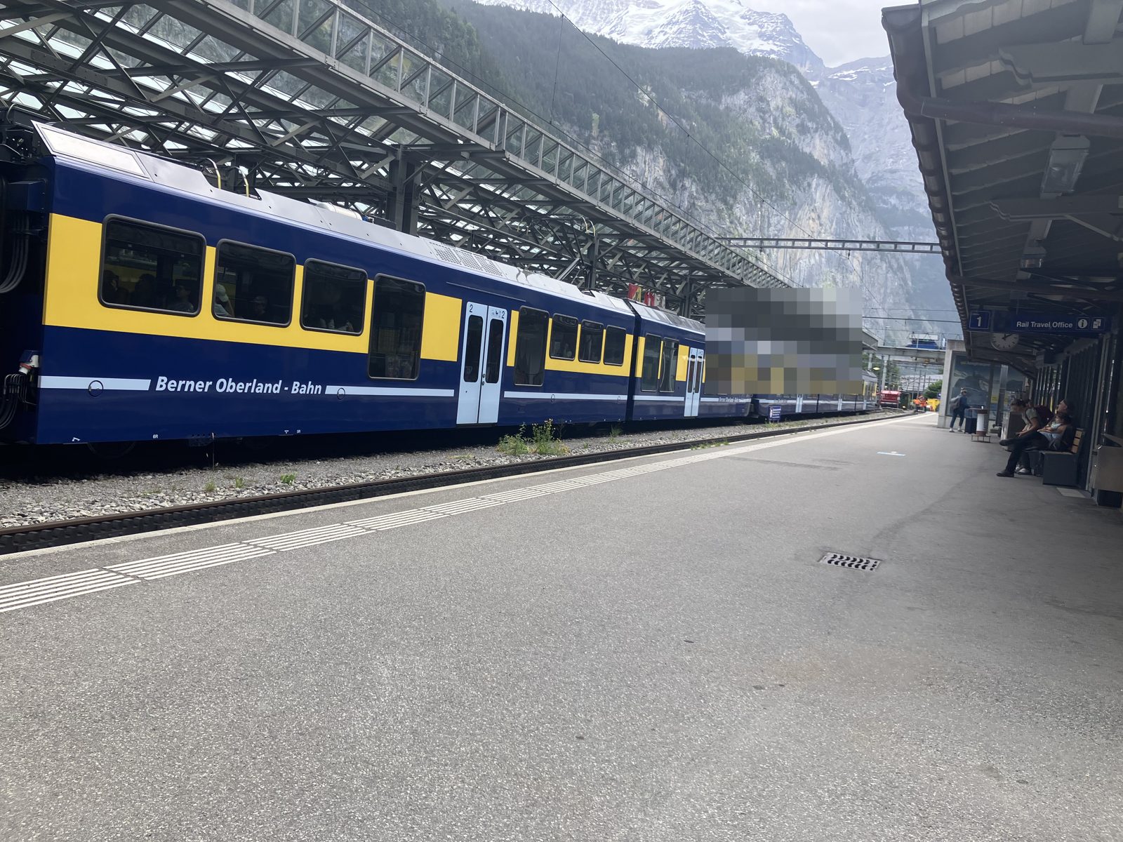 ホームに停車するベルナーオーバーラント鉄道の青と黄色の列車