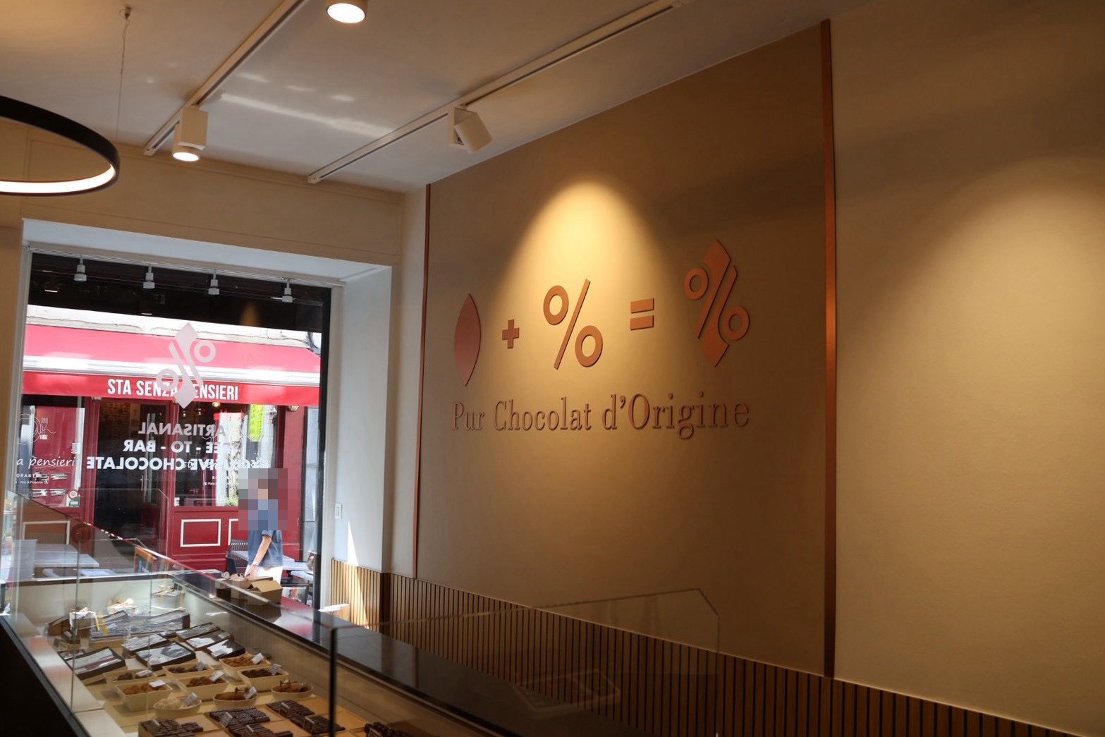アトリエ・サントカトリーヌの店内とPur Chocolat d'Origineの壁