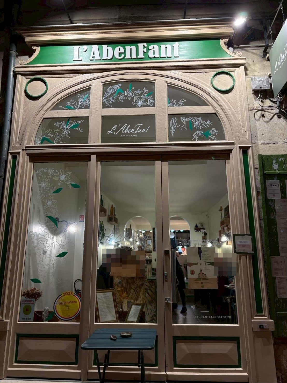 夜のL'AbenFantの店構え。緑の看板とガラス扉から店内の明かりがもれる
