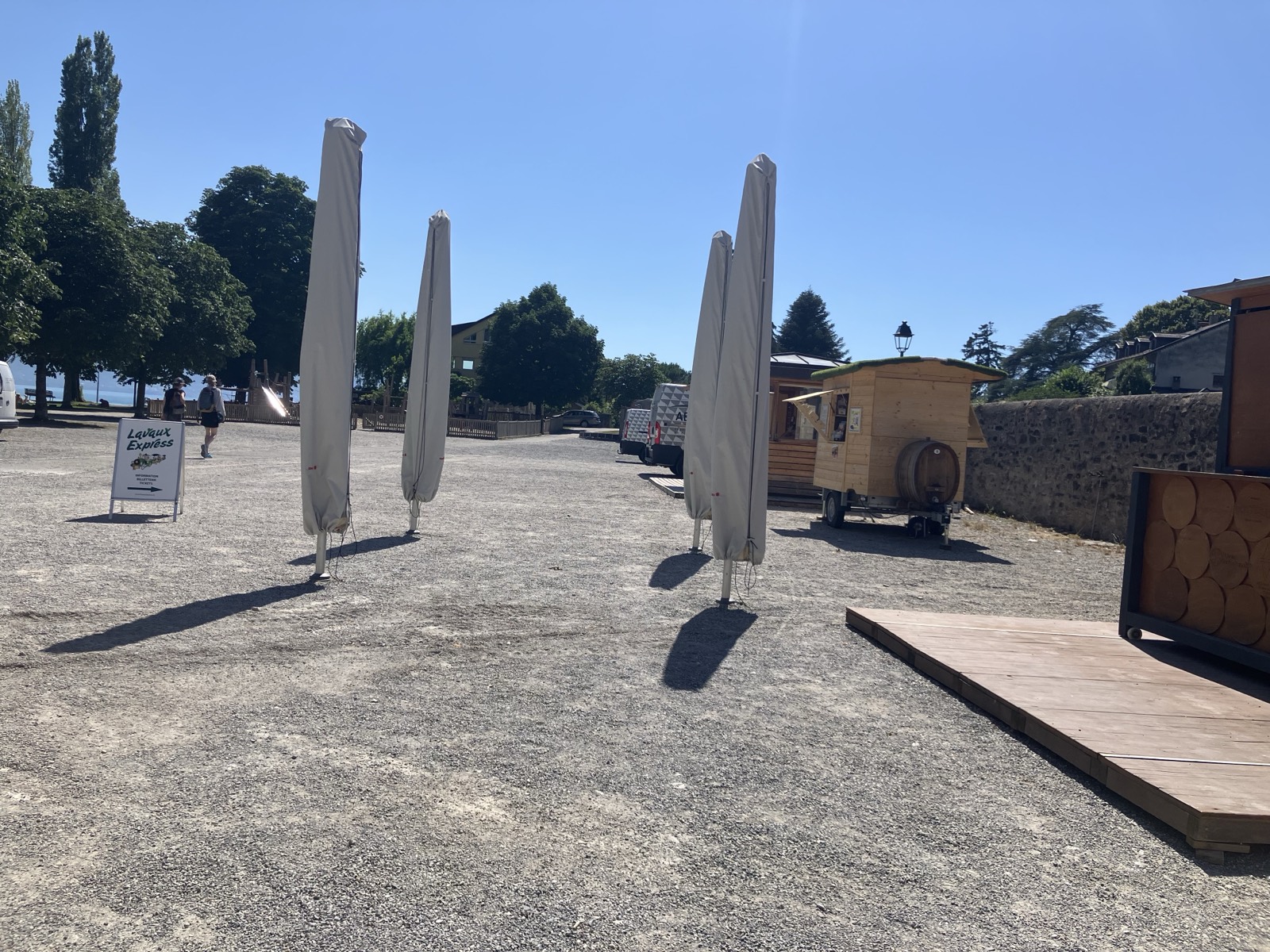 キュリーの乗り場広場。Lavaux Expressのチケット案内看板とワイン樽のワゴン