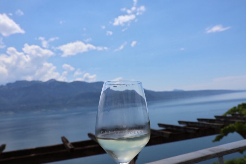 ドメーヌ・デュ・ブリニョンのテラスで。VINS DE LAUSANNEのグラス越しにレマン湖