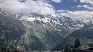 ミューレンの村の屋根越しにそびえる雪山の連峰